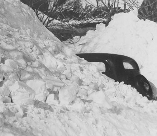 [Photo of an old car in a snowbank]