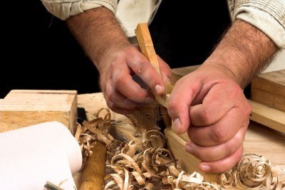 [Photo of the hands of a carpenter working with a plane]