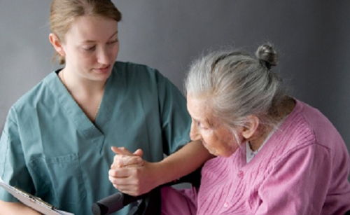 [Photo of a nurse helping an elderly woman]