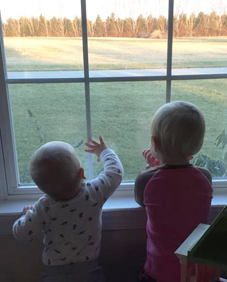 [Photo of two children watching for their dad to come home]