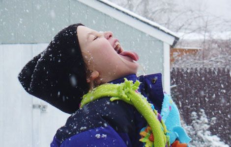 [Photo of a boy letting snow fall onto his tongue]