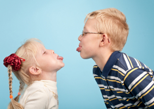 [Photo of two children sticking out their tongues at each other]