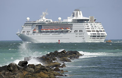 [Photo of a cruise ship near rocks]