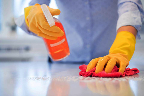 [Photo of someone disinfecting a counter]