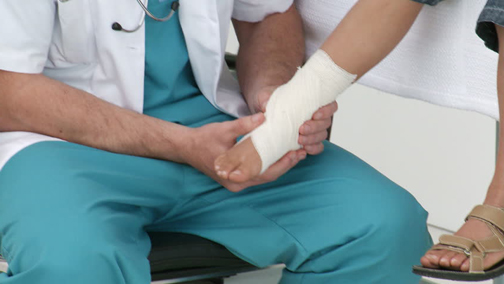 [Photo of a doctor examining a foot]