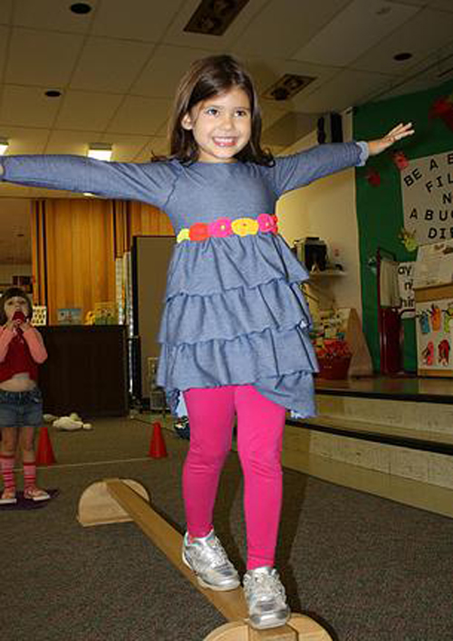[Photo of a little girl on a balance beam]