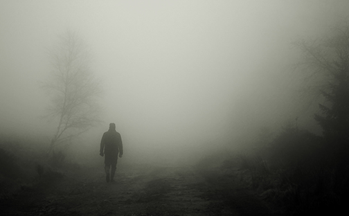 [Photo of a man walking in fog]
