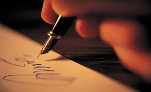 [Photo of signing a document]