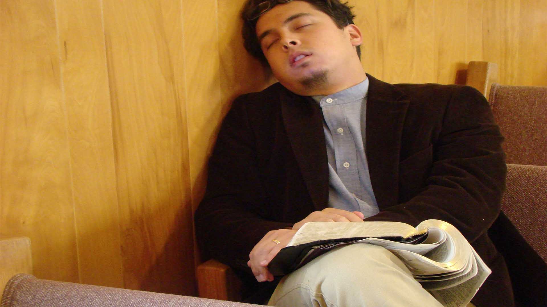 [Photo of a man sleeping in church]