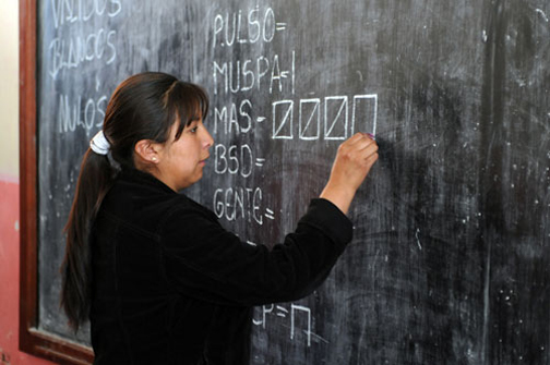 [Photo of a teacher with a chalk mark]