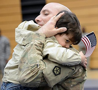 [Photo of a little boy welcoming his soldier father]