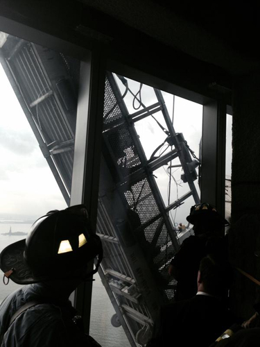 [Photo of fire department personnel rescuing trapped window washers]