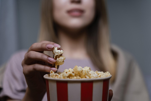 [Photo of a woman eating popcorn]