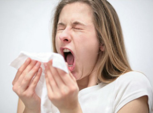 [Photo of a woman sneezing]