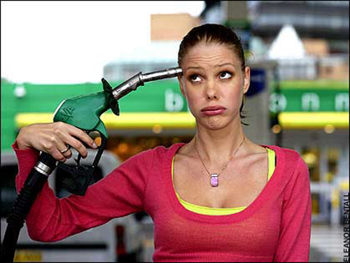 [Photo of a woman holding a fuel nozzle ot her head]