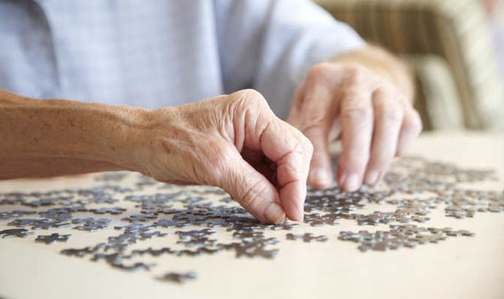 [Photo of people working on a jigsaw puzzle]